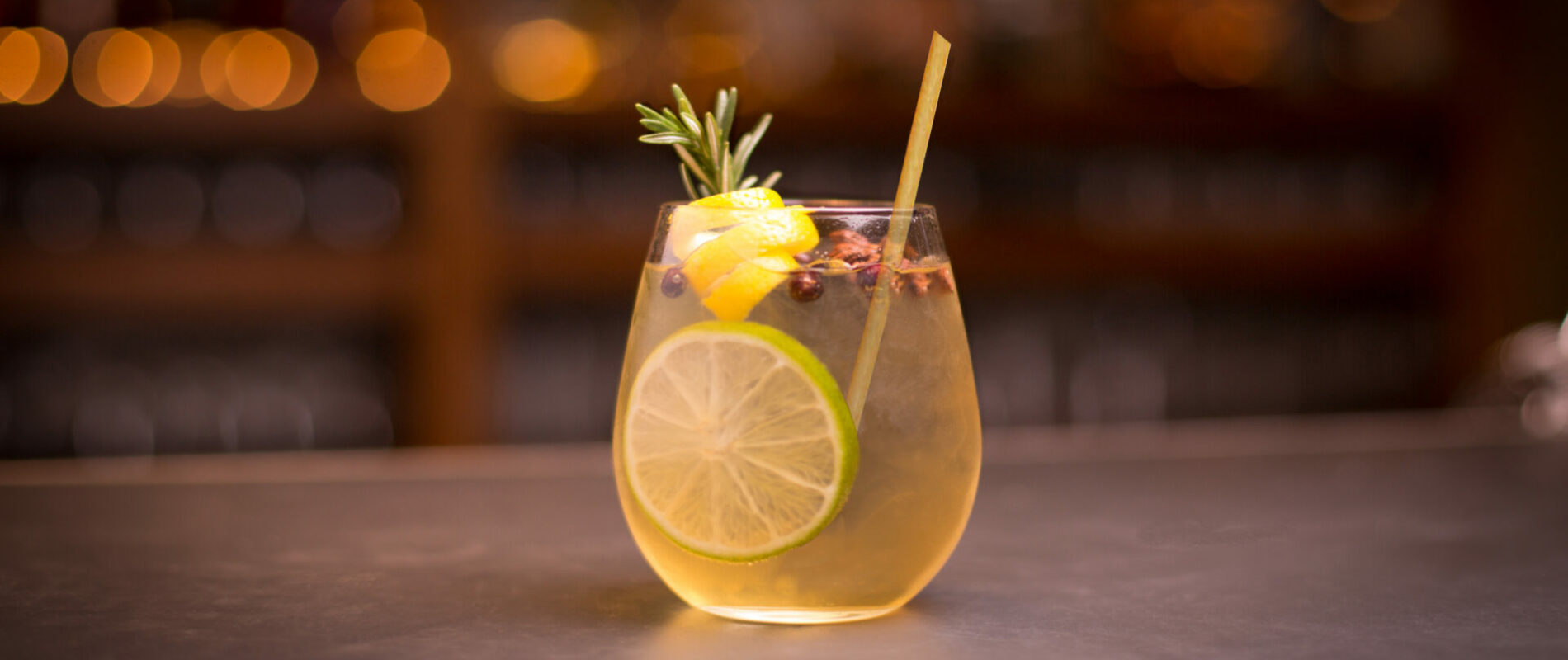 Gin and tonic cocktail with lemon and rosemary garnish