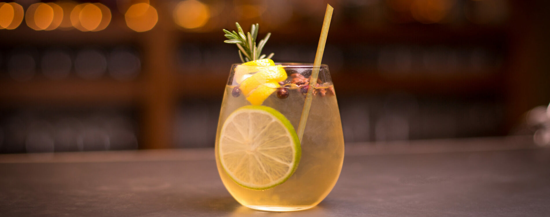Gin and tonic cocktail with lemon and rosemary garnish