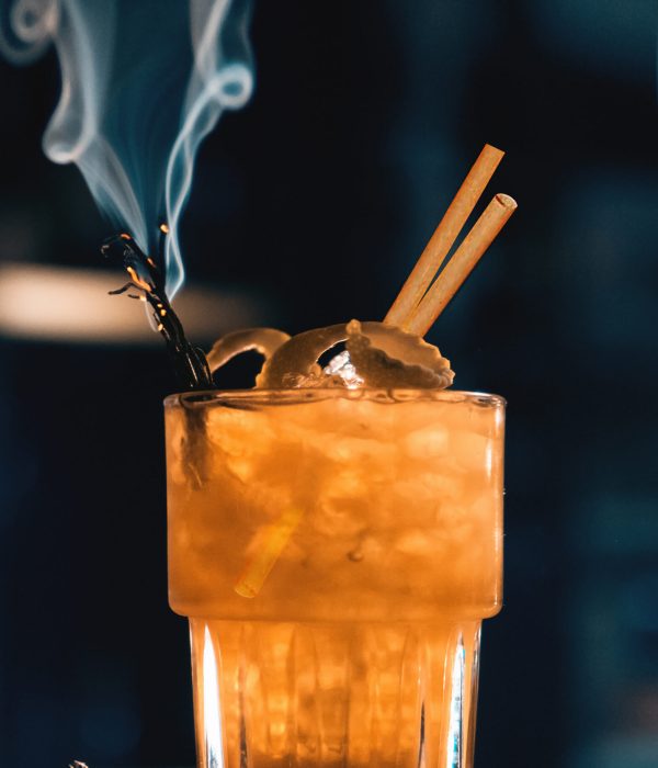 scottish bee cocktail with smoke on blue background;